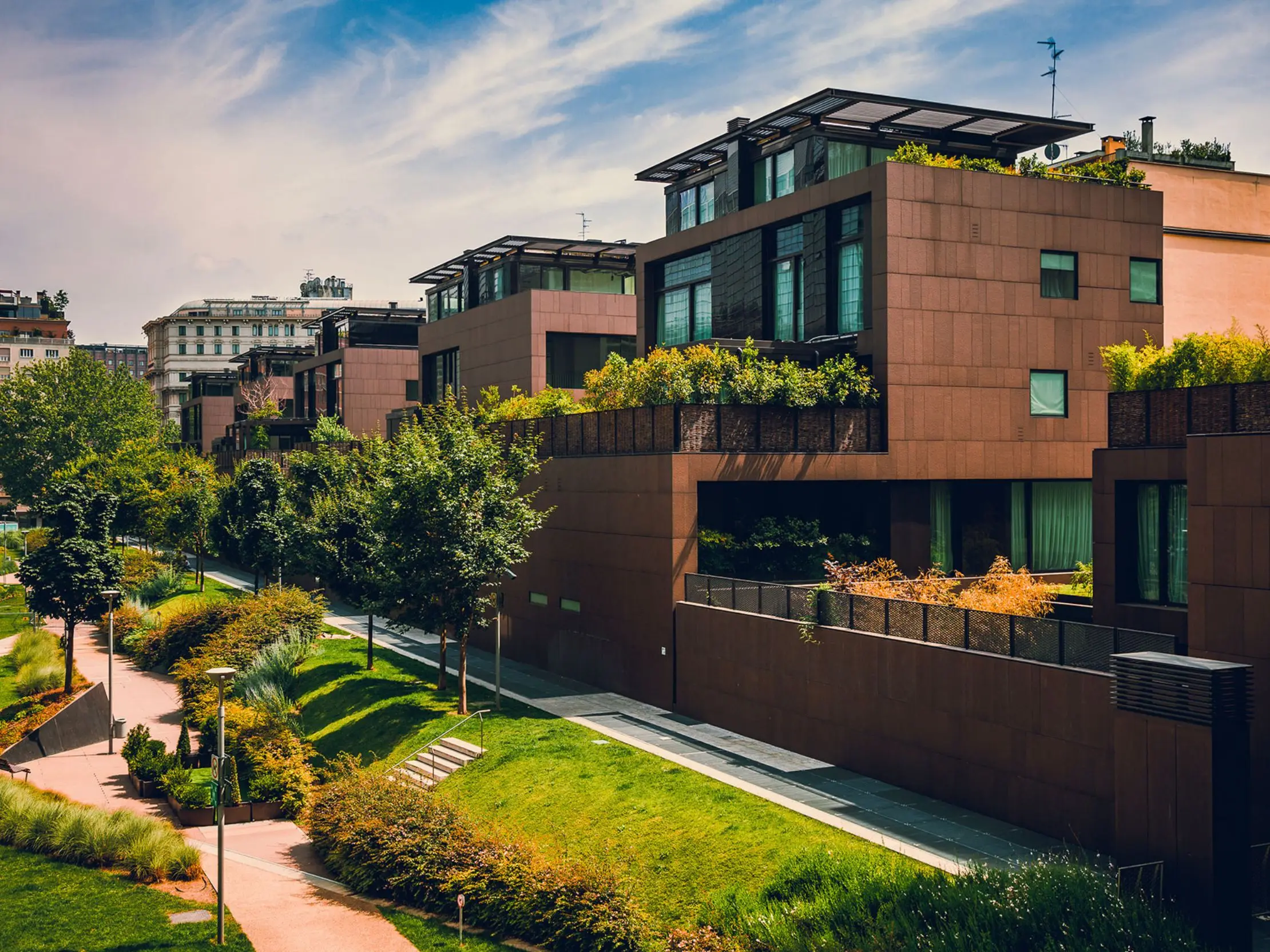 Modern multi-unit residential buildings with planted terraces and landscaped surroundings